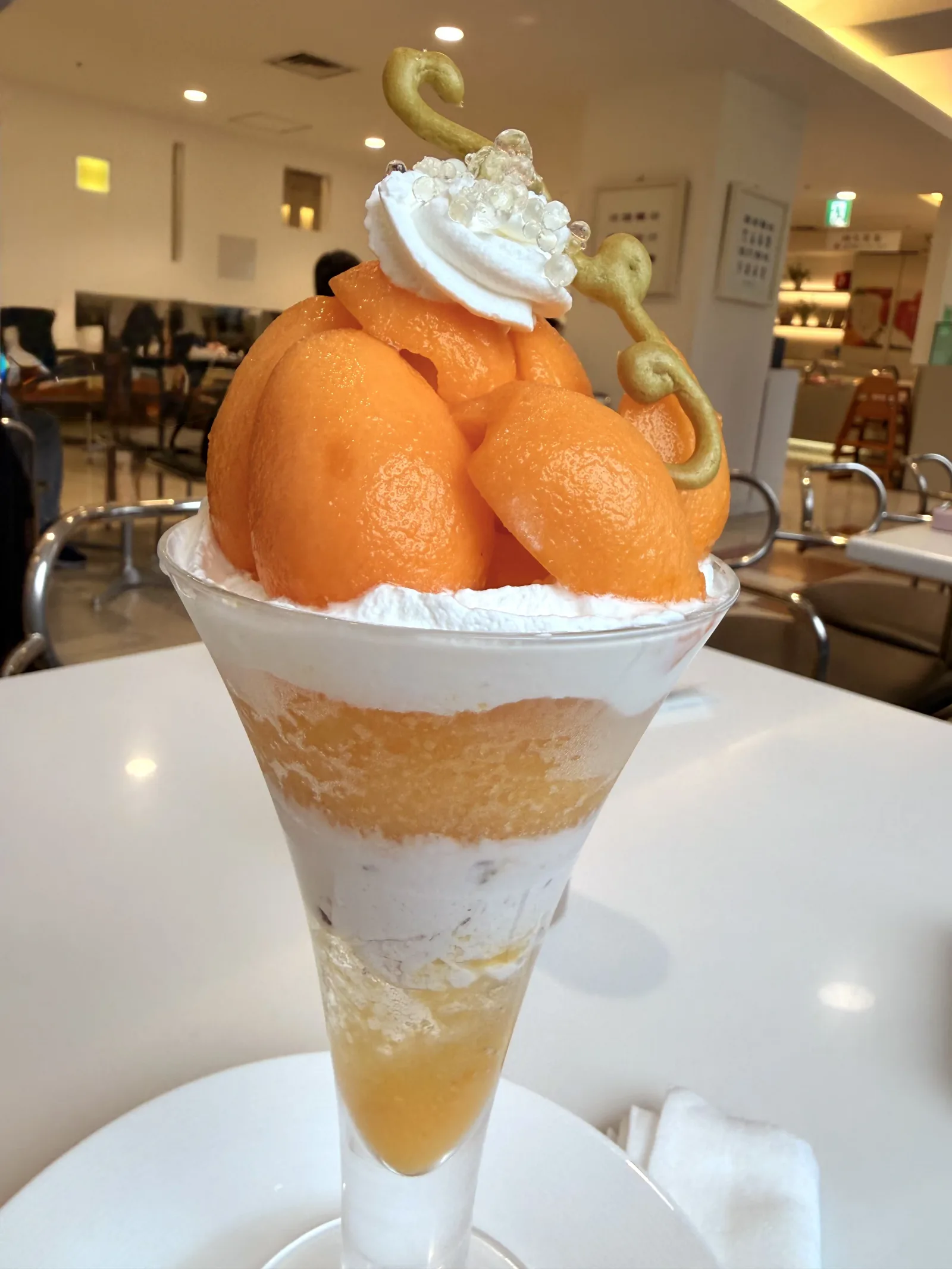 長崎県産茂木枇杷のパフェ。大ぶりの枇杷が上にいくつか乗っていて、よくわからない焼き物みたいなやつも乗っている